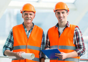 Pay As You Go Telephone Call Answering services Two men in high visibility PPE holding a clipboard and roll of paper